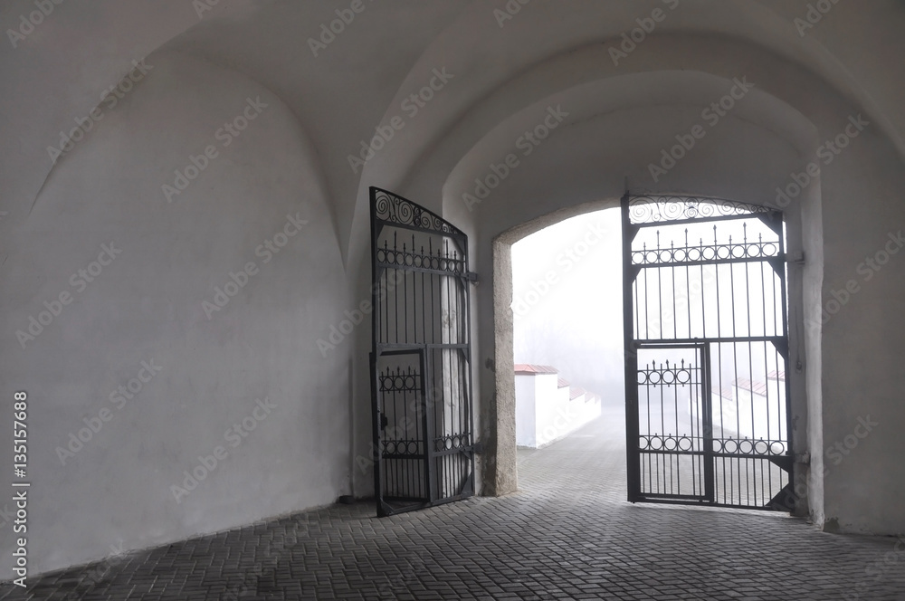Arch of an old castle with black metal gates. Grodno, Belarus. Arch of an old castle with black metal gates. Grodno, Belarus.