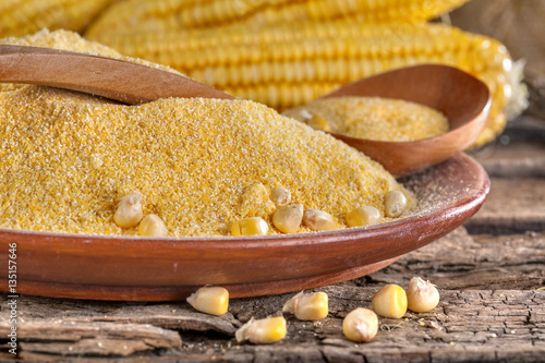 corn grits polenta in a wooden bowl on old wooden table