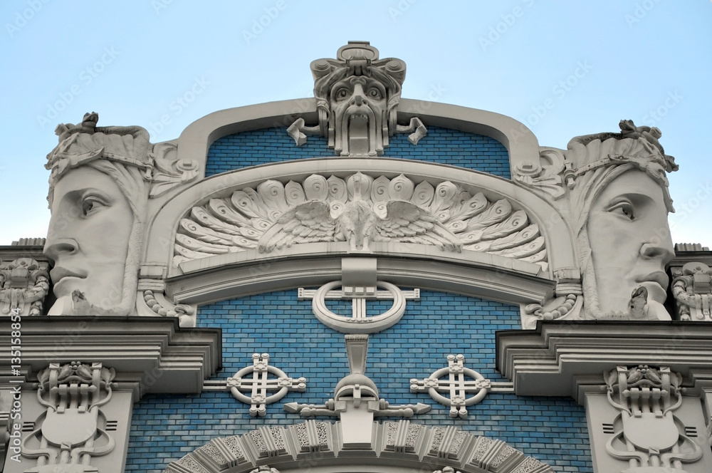 Facade of old building with sculptures of woman heads in Art Nouveau style (Jugendstil). Riga, Latvia.