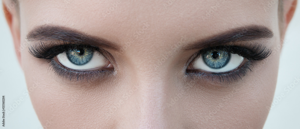 Close-up portrait of a beautiful girl with big blue eyes looking