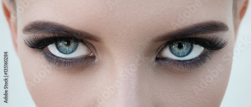 close-up face of pretty girl with beautiful big blue eyes, big eyelashes and eyebrows