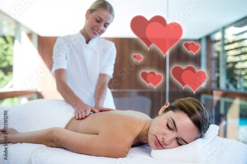 Composite image of a massage session with love hearts