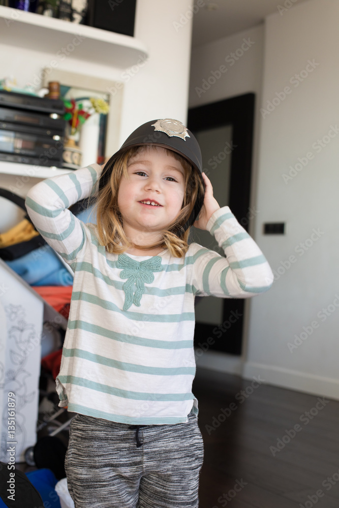 portrait of three years old blonde child with white and green shirt and black English Bobby policeman hat, with badge, looking and smiling, indoor
portrait of three years old blonde child with white and green shirt and black English Bobby policeman hat, with badge, looking and smiling, indoor