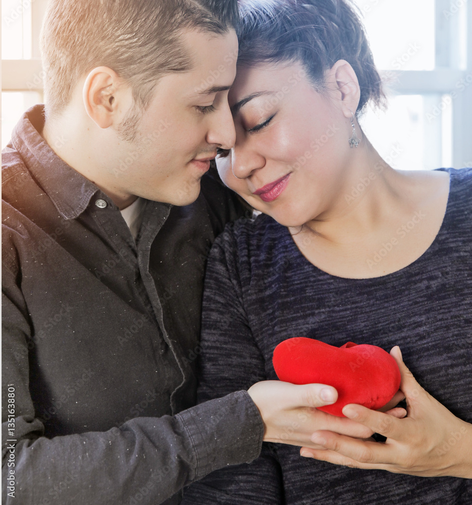 Latin couple of lovers hugging and holding Heart toy in Valentin Latin couple of lovers hugging and holding Heart toy in Valentin