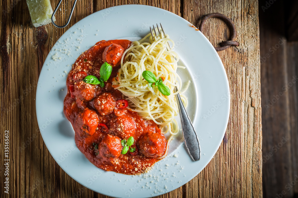 Enjoy your spaghetti bolognese with meatballs and parmesan Enjoy your spaghetti bolognese with meatballs and parmesan