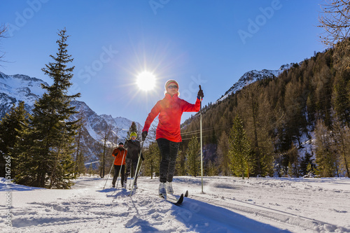 A family group of cross country skiers on a sunny winter morning