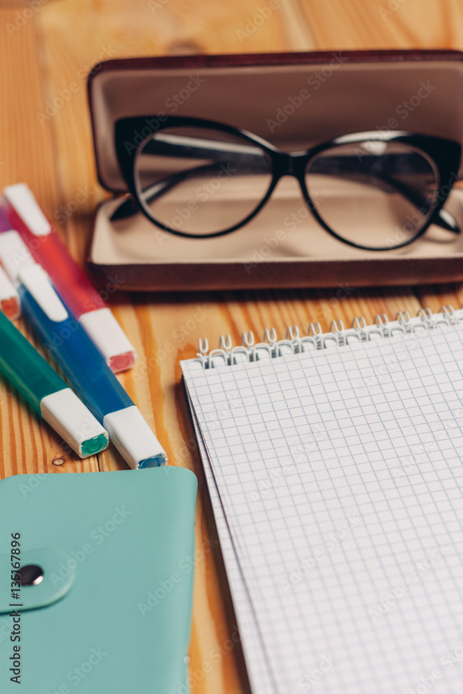 Glasses in a case and notepad with markers Glasses in a case and notepad with markers