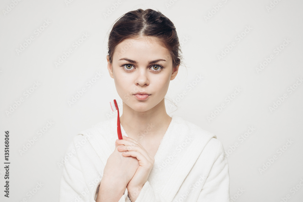 confident look of a woman in a white coat and with a toothbrush confident look of a woman in a white coat and with a toothbrush