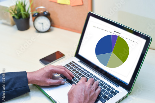 Financial Planning Concept,man is working by using a laptop with sales chart on monitor screen. photo