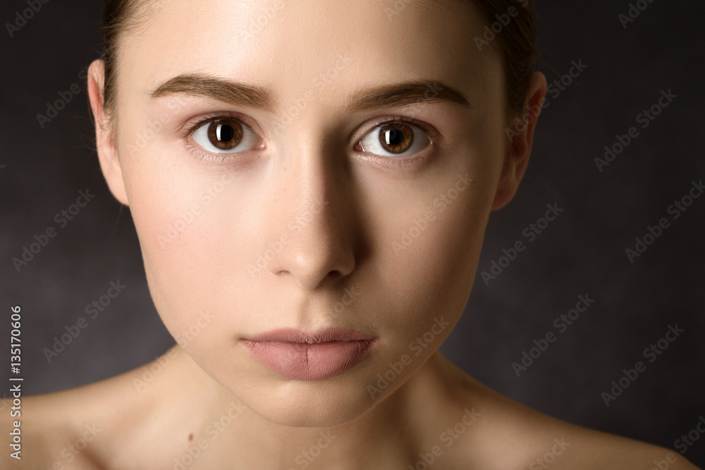 Woman with a natural beauty makeup look over a black background Woman with a natural beauty makeup look over a black background