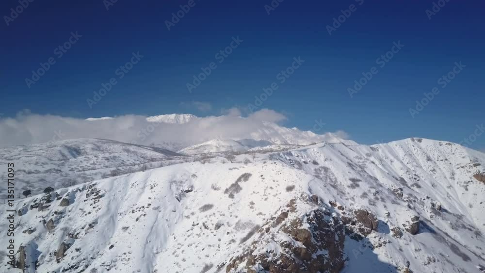 Aerial fly down steep winter snow mountain rocky. Mount Nebo wilderness area, scenic byway. Winter snow on landscape. Cold season weather. Nature and environment. Drone flight. Aerial fly down steep winter snow mountain rocky. Mount Nebo wilderness area, scenic byway. Winter snow on landscape. Cold season weather. Nature and environment. Drone flight.