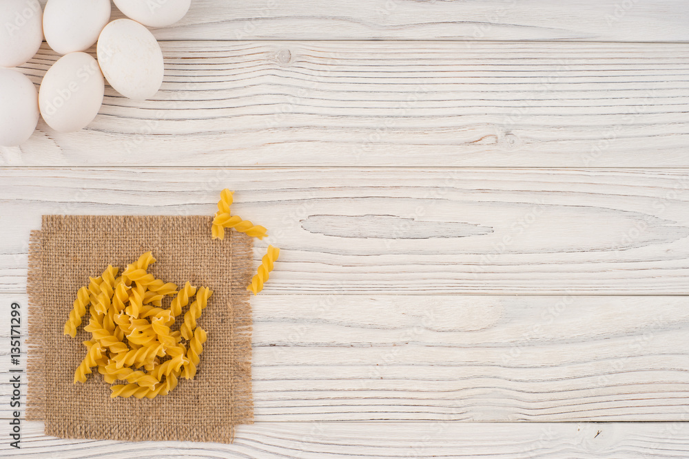 Pasta and chicken eggs on an old white wooden table. Pasta and chicken eggs on an old white wooden table.