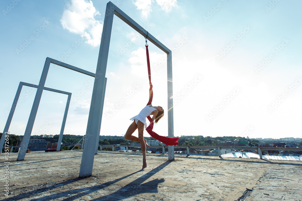 Beautiful aerial dancer, silk dance on roof at sunrise Beautiful aerial dancer, silk dance on roof at sunrise