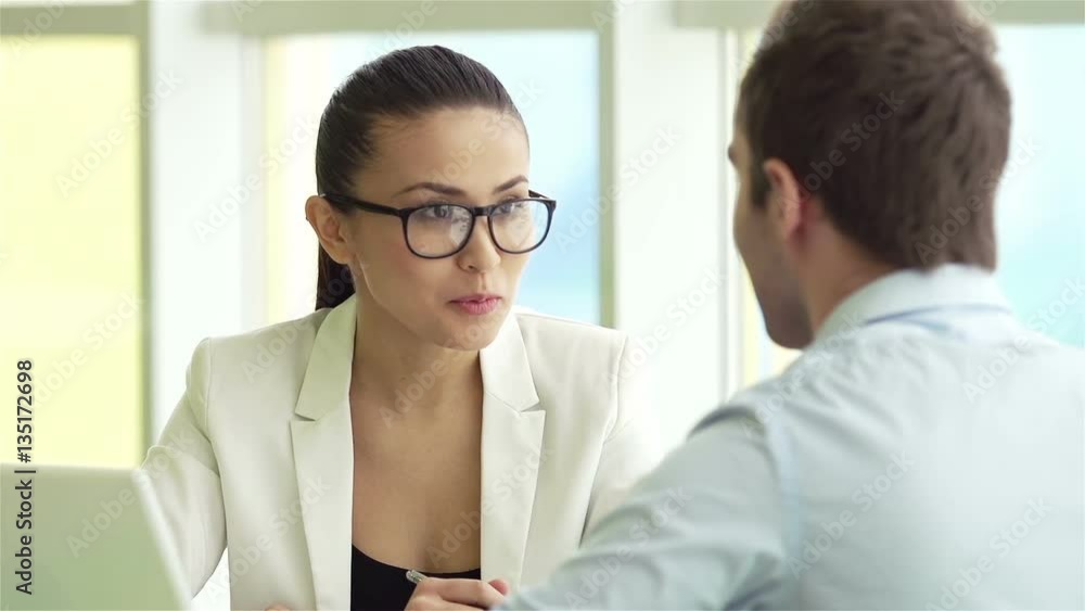 Elegant businesswoman in eyeglasses explaining her idea to man Elegant businesswoman in eyeglasses explaining her idea to man