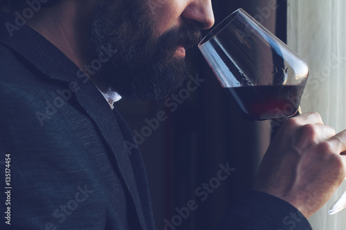 man tasting a glass of red wine