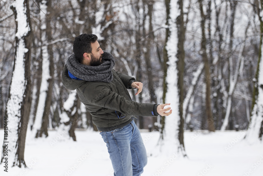 Fototapeta premium Snowball fight. A man throwing a snowball