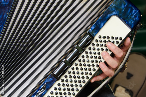 Musician pressing buttons on piano accordion