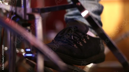 Man playing base drum pedal on stage. photo