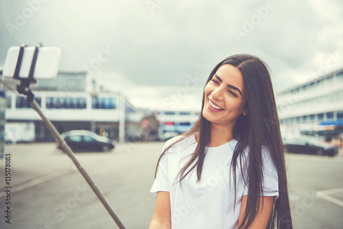 Camera held on stick by smiling woman