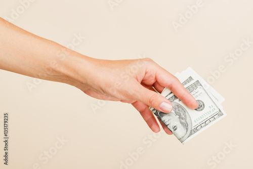Woman's hand with money on a light background