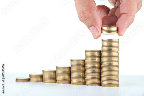 man hand putting money to rising coin stacks on white background