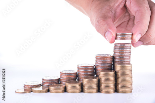 man hand putting money to rising coin stacks on white background