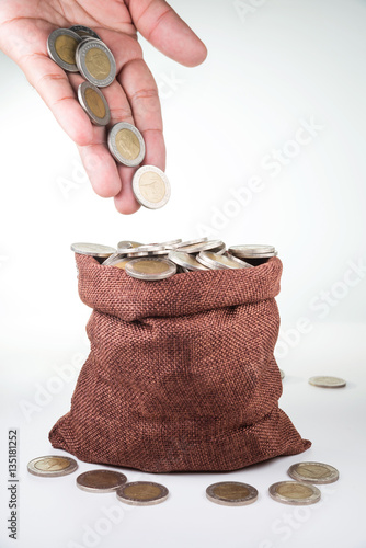 coins splash out from man hand drop to coin bag , business growi photo