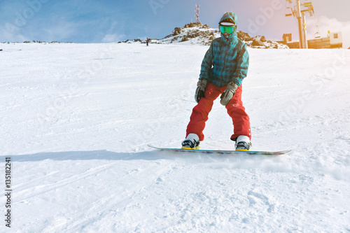 Beginner snowboarder girl wears her google mask and bright clothes, practice her riding skills with backside edge breaking on top of snowy ski slope near lift, isolated on right side