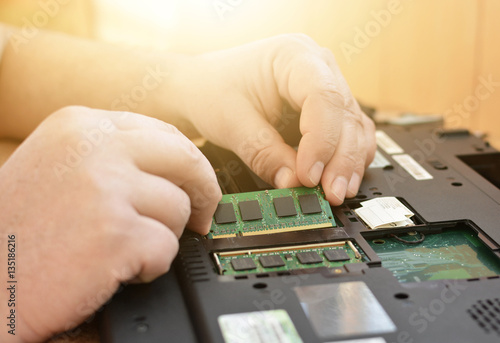 Engineer restores the laptop PC. Installing the hard drive hardware, RAM. Electronic repair shop, technology renovation, business, concept repairs.