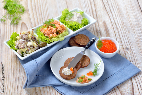 Canvas Print Gemischte Fischvorspeise mit Lachstatar, Matjestatar, Forellencreme und Kaviar -