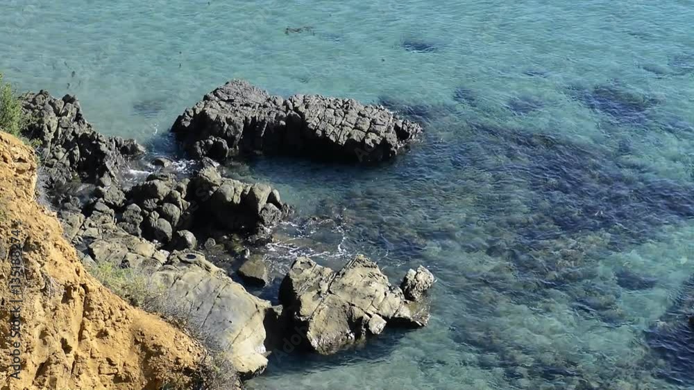 Turquoise water gently surges around a reef during a bright, sunny day. Turquoise water gently surges around a reef during a bright, sunny day.