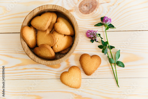 Heart shaped cookies,flowers on wooden table background.Top view