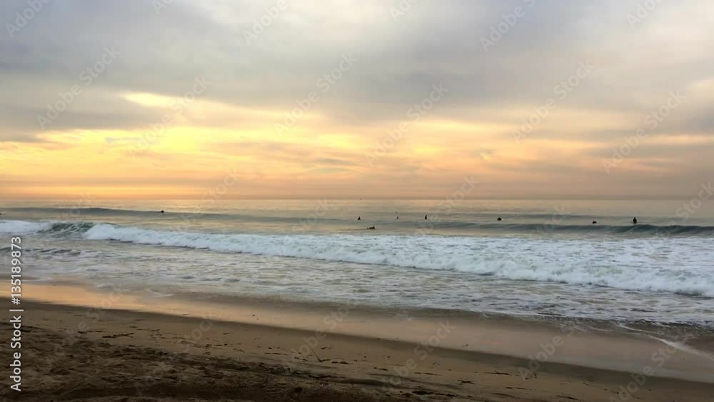 Wide perspective of a beautiful beach and ocean waves in Huntington Beach, California framed against a pastel sunrise. Wide perspective of a beautiful beach and ocean waves in Huntington Beach, California framed against a pastel sunrise.