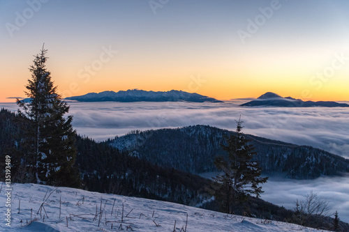 Beautiful sunrise in winter Little Fatra mountains above low clo