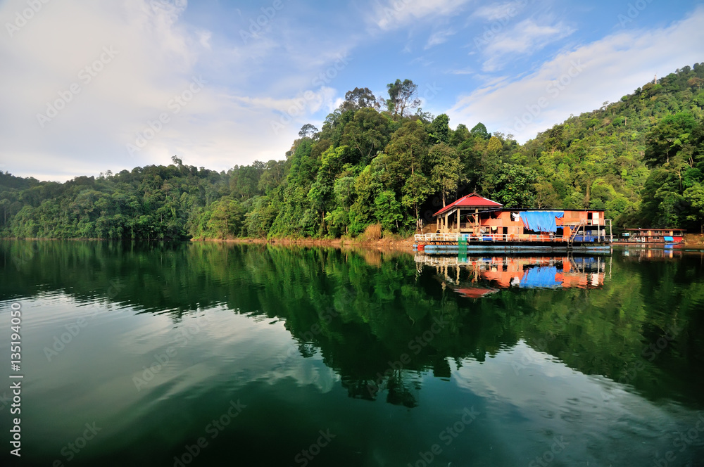 Fishing boat (Houseboat) at tropical rain forest at Kenyir Lake in Terengganu, Malaysia, It is the largest man-made lake in South East Asia. Fishing boat (Houseboat) at tropical rain forest at Kenyir Lake in Terengganu, Malaysia, It is the largest man-made lake in South East Asia.