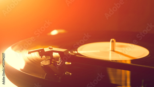Vintage record player with vinyl disc, close-up. warm sunlight
