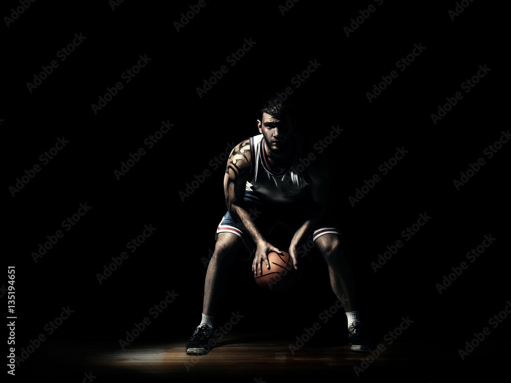 basketball player in durkness on parquet with ball