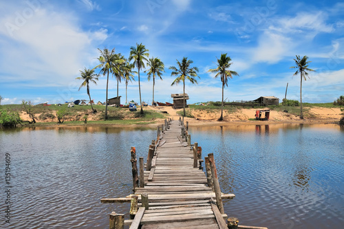 wooden jetty, Landscape scene of Malaysia fisherman traditional village, Terengganu with coconut tree and well in a blue sky.