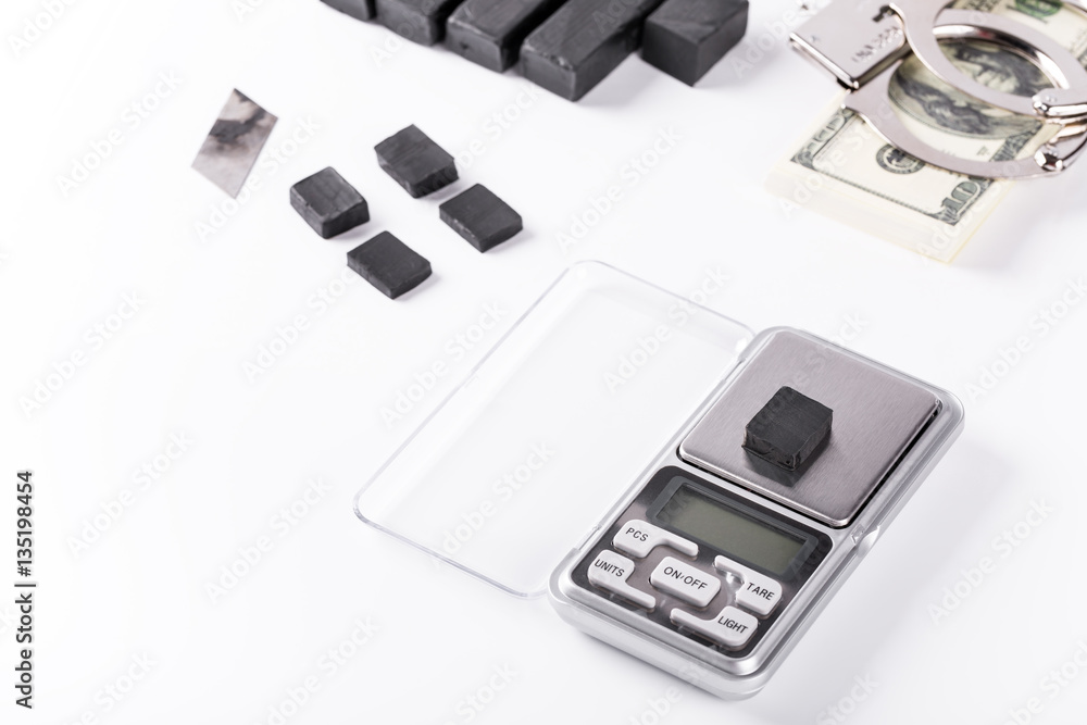 Blocks of hashish on digital scales over white background Blocks of hashish on digital scales over white background