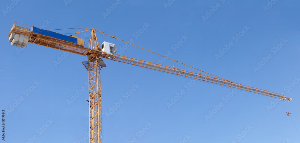 Big construction crane against the clean blue sky. Big construction crane against the clean blue sky.