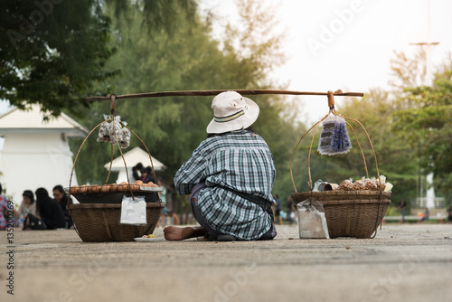 Unidentified women peddler hawker selling eggs potatoes on the street in Thailand.