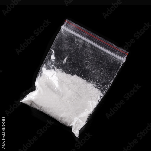 Cocaine in plastic packet on black background photo