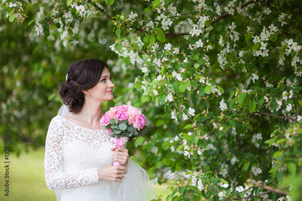 Young beautiful woman, bride with wedding bouquet in blooming garden Young beautiful woman, bride with wedding bouquet in blooming garden