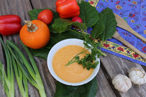 Pumpkin soup in Russian folk art khokhloma bowl with vegetables