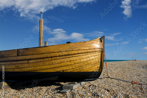 Traditional wooden fishing boat on shingle beach in Kent, England