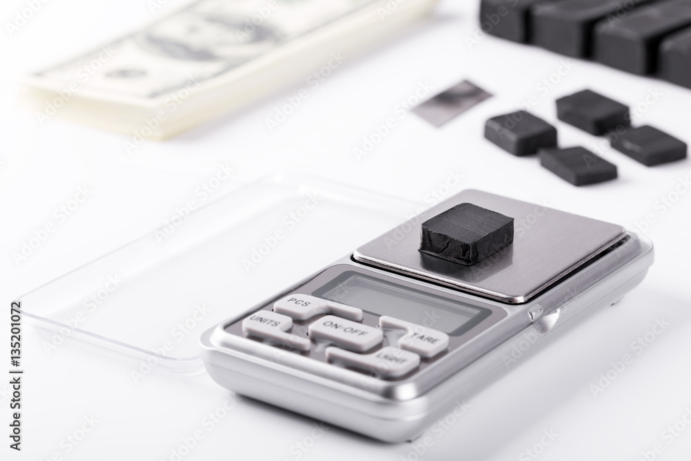 Blocks of hashish on digital scales over white background Blocks of hashish on digital scales over white background