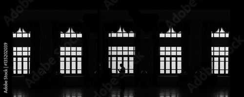 silhouette glass window home with a man, selective focus on the middle glass window, processed in black and white or monochrome. silhouette of a grand ball room with glass windows