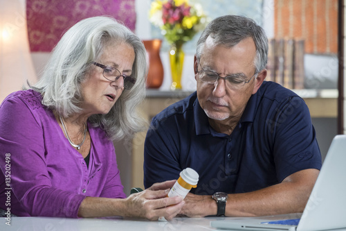 A senior aged couple reading the label on a prescription bottle photo