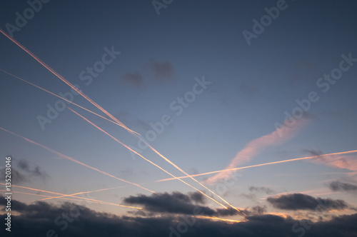 Traces of the plane in the very beautiful and colorful sky before the sunset. Many planes crossroads in the sky.