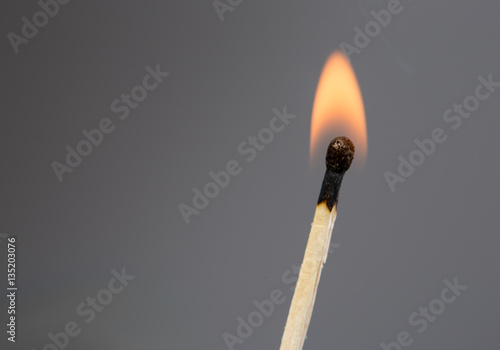 burning match on a gray